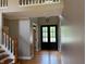 Bright foyer with hardwood floors, a staircase, and a view of the front door at 5775 Coopers Hawk Dr, Carmel, IN 46033