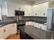Updated kitchen featuring white cabinets, stainless steel appliances, and black granite countertops at 5775 Coopers Hawk Dr, Carmel, IN 46033