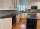 Bright kitchen with white cabinets, dark countertops, and stainless steel appliances at 5775 Coopers Hawk Dr, Carmel, IN 46033