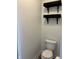 Neutral powder room featuring a toilet and floating shelves at 5775 Coopers Hawk Dr, Carmel, IN 46033