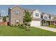 Well-manicured front yard with a beautiful tree framing a two-story home with brick and siding exterior at 5809 Terracotta Trce, McCordsville, IN 46055
