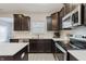 Kitchen with dark cabinets, stainless steel appliances, quartz counters, and an island for extra prep space at 5809 Terracotta Trce, McCordsville, IN 46055