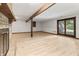 Basement featuring a brick fireplace, wood-look flooring and beams leading to a glass door to the outside at 604 Oak Blvd W Dr, Greenfield, IN 46140