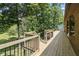 New wood deck features black metal railing with a view of the wooded backyard at 604 Oak Blvd W Dr, Greenfield, IN 46140