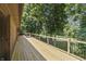 Side view of the wood deck featuring black metal railing overlooking the lush, green backyard at 604 Oak Blvd W Dr, Greenfield, IN 46140