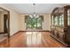 Dining room features hardwood floors, a chandelier, hutch, and outdoor view through a large window at 604 Oak Blvd W Dr, Greenfield, IN 46140