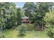 Brick home with fenced yard and a deck surrounded by mature trees at 604 Oak Blvd W Dr, Greenfield, IN 46140