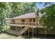 Back of house exterior showcasing a brick home with a large deck and stairs leading down at 604 Oak Blvd W Dr, Greenfield, IN 46140