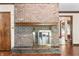 Close up of a brick fireplace with wood mantle, tile hearth, and metal door in living room at 604 Oak Blvd W Dr, Greenfield, IN 46140