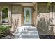 Brick home entrance with a white door featuring an oval window, concrete steps, and dark mulch landscaping at 604 Oak Blvd W Dr, Greenfield, IN 46140