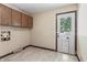 Functional laundry area with wall cabinets, tile floor, and access to the outside, ideal for chores at 604 Oak Blvd W Dr, Greenfield, IN 46140