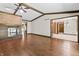 Bright living room with hardwood floors, brick fireplace, exposed beams, and an open floor plan to the dining room at 604 Oak Blvd W Dr, Greenfield, IN 46140