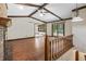 Living room with hardwood floors, fireplace, exposed beams, and balcony access offering stunning views of the backyard at 604 Oak Blvd W Dr, Greenfield, IN 46140