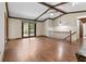 Spacious living room with hardwood floors, exposed beams, and access to the deck through sliding glass doors at 604 Oak Blvd W Dr, Greenfield, IN 46140