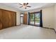 A bright main bedroom with a ceiling fan, slider to the deck, and a walk-in closet at 604 Oak Blvd W Dr, Greenfield, IN 46140
