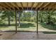 View of a large, grassy, fenced backyard from underneath the covered wood deck at 604 Oak Blvd W Dr, Greenfield, IN 46140