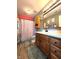 A charming bathroom features a wood vanity and a cute shower curtain at 6161 E Runnymede Ct, Camby, IN 46113