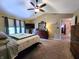 The main bedroom offers a ceiling fan, carpeted floors, a dresser, and TV at 6161 E Runnymede Ct, Camby, IN 46113