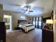 The main bedroom offers a ceiling fan, carpeted floors, and a private en suite bathroom at 6161 E Runnymede Ct, Camby, IN 46113