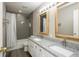 Bathroom featuring double sinks with granite countertops, complemented by a tiled shower and gray walls at 6465 Robinsrock Dr, Indianapolis, IN 46268