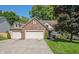 Charming two-story brick home with a well-manicured lawn and a spacious three-car garage and driveway at 6465 Robinsrock Dr, Indianapolis, IN 46268