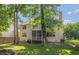 Backyard view of the two story home with a screened in porch and mature trees at 6465 Robinsrock Dr, Indianapolis, IN 46268