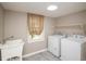 Functional laundry room featuring a utility sink, shelving, and washer and dryer at 6465 Robinsrock Dr, Indianapolis, IN 46268
