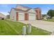 Charming two-story home with a well-manicured lawn, a three-car garage and a red brick facade at 7350 Gold King Way, Indianapolis, IN 46259