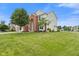 Charming two-story home with a well-manicured lawn, a three-car garage and a red brick facade at 7350 Gold King Way, Indianapolis, IN 46259