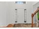 Bright foyer with wood floors, a large arched window, and a staircase with wood railing at 7350 Gold King Way, Indianapolis, IN 46259