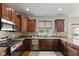 Well-equipped kitchen featuring stainless steel appliances, granite counters, and dark wood cabinetry at 7350 Gold King Way, Indianapolis, IN 46259