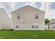 View of the home's rear exterior and backyard with green lawn at 7572 Wymm Ln, Ingalls, IN 46048