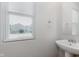 Bright bathroom featuring a pedestal sink, window with blinds, and a mirror at 7572 Wymm Ln, Ingalls, IN 46048