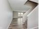 A foyer with a staircase and view to the living room and wood-look vinyl plank flooring at 7572 Wymm Ln, Ingalls, IN 46048