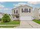 Two-story home features a two-car garage, lawn, and a welcoming front entrance at 7572 Wymm Ln, Ingalls, IN 46048