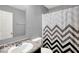 Bathroom featuring a stylish chevron-patterned shower curtain, sink, and vanity with a mirror at 7865 Danube St, Indianapolis, IN 46239