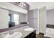 Bathroom featuring dual sinks, a large mirror, a storage shelf, and a soaking tub at 7865 Danube St, Indianapolis, IN 46239