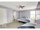 Bright bedroom showcasing a ceiling fan, two beds, and large windows for natural light at 7865 Danube St, Indianapolis, IN 46239
