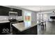 Modern kitchen features an island, dark cabinets, and stainless steel appliances at 7865 Danube St, Indianapolis, IN 46239