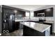 Kitchen featuring stainless steel appliances, a spacious island, and dark cabinets at 7865 Danube St, Indianapolis, IN 46239