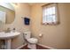 Functional powder room with a toilet, pedestal sink, and natural light at 8047 Red Barn Cir, Indianapolis, IN 46239