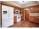 Well-lit kitchen with white appliances, wood cabinets, and wood-look floors at 8047 Red Barn Cir, Indianapolis, IN 46239