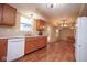 Open kitchen and dining area features wooden cabinets, white appliances and wood-look flooring at 8047 Red Barn Cir, Indianapolis, IN 46239