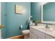 Stylish half bathroom with teal walls, modern fixtures, and a decorative mirror enhancing the space's charm at 9525 Longwell Dr, Indianapolis, IN 46240