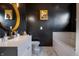 Elegant bathroom with black walls, a round gold mirror, and marble tile flooring, creating a luxurious feel at 9525 Longwell Dr, Indianapolis, IN 46240