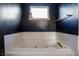 Relaxing bathroom showcasing a deep soaking tub with gold fixtures, surrounded by classic white tile at 9525 Longwell Dr, Indianapolis, IN 46240
