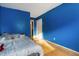 Bedroom with warm wood floors, blue walls, and natural light creating a welcoming and open space at 9525 Longwell Dr, Indianapolis, IN 46240