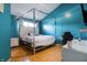Modern bedroom featuring a unique canopy bed, bright blue walls, and warm hardwood floors at 9525 Longwell Dr, Indianapolis, IN 46240