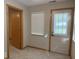 A bedroom with carpeting leads to an exterior door and window at 989 Plaza Dr, Martinsville, IN 46151
