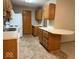 Kitchen features light oak cabinets, white appliances, and vinyl flooring for an open and functional space at 989 Plaza Dr, Martinsville, IN 46151